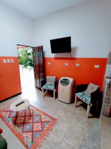 a living room with a tv and a table and chairs at Nirvana Apartament Hostal in Alajuela