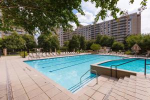 una grande piscina con sedie e un edificio di Luxury condo @Crystal City with Amazing Amenities ad Arlington