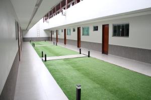 an empty hallway with green grass in a building at Hotel Park in Valparaíso de Goiás