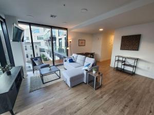 a living room with a white couch and a large window at NYC Vibe 2BR Apt - Close to Times Square in Weehawken