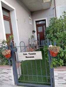 a sign on a gate in front of a house at Casa Vacanze MURANUM - B&B in Morano Calabro