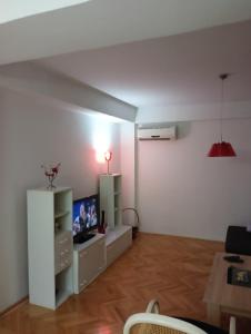 a living room with a tv and a white wall at ANAHOME in Gevgelija +2 photos