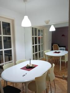 a dining room with two white tables and chairs at ANAHOME in Gevgelija