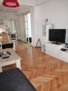 a living room with a wooden floor and a flat screen tv at ANAHOME in Gevgelija