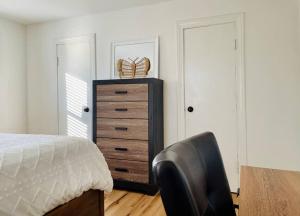 a bedroom with a dresser and a bed with a chair at Heavensville Haven - One bedroom apartments in Evansville