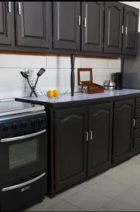 a kitchen with black cabinets and a stove at Cradock Guest House in Cradock