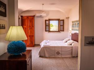1 dormitorio con 1 cama y 1 mesa con lámpara en I Mandorli, en Lotzorai