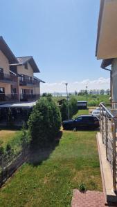 un patio con coches estacionados al lado de un edificio en Apartament CALMA, en Krynica Morska