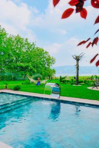 une personne assise dans un hamac à côté d'une piscine dans l'établissement Lotus Sapanca-Private Villa with private Pier and heated pool, à Serdivan