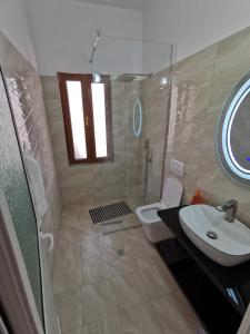 a bathroom with a shower and a sink and a toilet at Bujtina Valgent in Berat