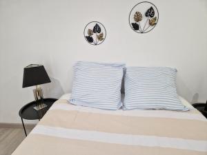 a bed with two pillows and two plates on the wall at Maison de village en Provence in Sainte-Tulle