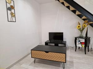 a living room with a tv and a coffee table at Maison de village en Provence in Sainte-Tulle