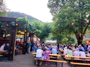 a crowd of people sitting at tables in a park at Haus an der Mosel in Bruttig-Fankel