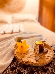 ein Tablett mit einer Kerze und einer gelben Blume auf einem Bett in der Unterkunft Pousada Do Porto in Barreirinhas