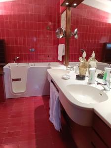 ein Badezimmer mit einer Badewanne, einem Waschbecken und einer Badewanne in der Unterkunft Chez Queen B&B in Lurate Caccivio