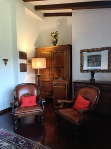 ein Wohnzimmer mit 2 Stühlen und einer Lampe in der Unterkunft Chez Queen B&B in Lurate Caccivio
