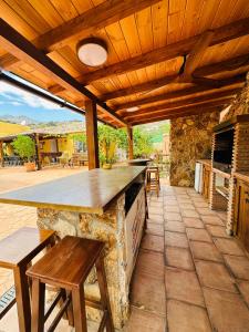 una cocina al aire libre con mesa y bancos en un patio en Cortijo el Alcornocal en Málaga