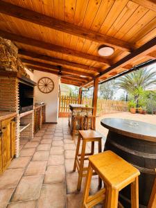 un patio con mesa y taburetes y un bar en Cortijo el Alcornocal, en Málaga