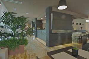 a lobby with potted plants in a building at Zen Hotel Versilia in Marina di Pietrasanta