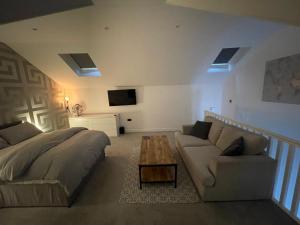 um quarto com uma cama, um sofá e uma mesa em Welcome properties - Self Check-In whole apartment em Swindon