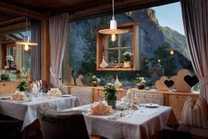 a restaurant with two tables with white tablecloths at Gramai Alm alpengenuss & natur spa in Pertisau