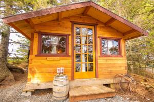 uma pequena cabina de madeira com janelas e um barril em Between Beaches Alaska em Seldovia