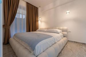 uma grande cama branca num quarto com uma janela em Altido Luxury Apartments em Budva