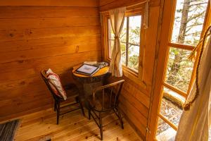 um quarto com uma mesa e duas cadeiras num chalé de madeira em Between Beaches Alaska em Seldovia