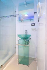 a bathroom with a green sink in a shower at Hostal Mamamambo in Santo Domingo