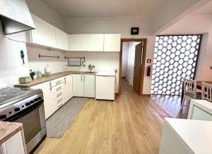 a kitchen with white cabinets and a wooden floor at Olivais Spacious Apartment near airport in Lisbon