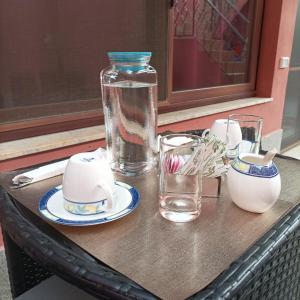 een tafel met een vaas en borden en glazen erop bij la Maison del Mas Family in Elmas