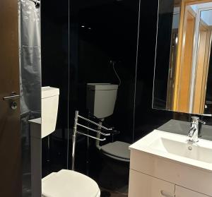 a black bathroom with a toilet and a sink at Olivais Spacious Apartment near airport in Lisbon