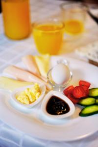 a plate of food with eggs and fruit on a table at Hotel Gorica - UNESCO quarter in Berat