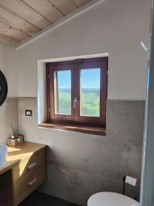 a bathroom with a toilet and a window at Casa Linda in Siena
