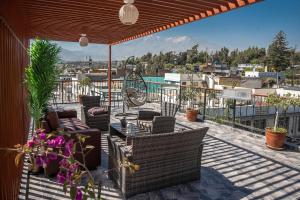 a patio with chairs and tables on a roof at Hotel Maison Du Solei in Arequipa