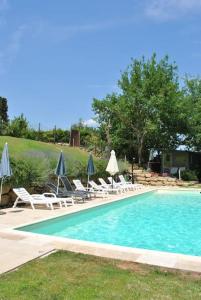 a swimming pool with lounge chairs and umbrellas at Casa Linda in Siena