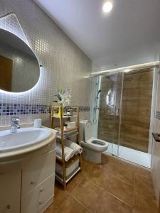 a bathroom with a sink and a toilet and a shower at PLAYA Finisterre in Fisterra +12 photos