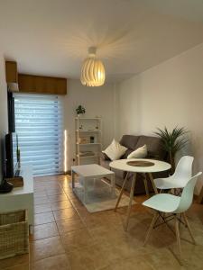 a living room with a couch and a table and chairs at PLAYA Finisterre in Fisterra