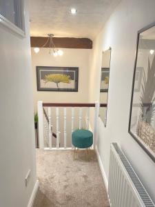 a stairway with a green chair in a room at Mount Yard - Stylish Cottage - Close to Alton Towers - Peak District - Stoke-on-Trent Sleeps 5 in Totmonslow