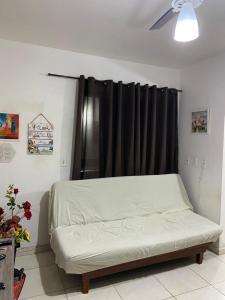 a bed in a room with a black curtain at Apart - em frente á praia dos milionários- Ilhéus in Ilhéus