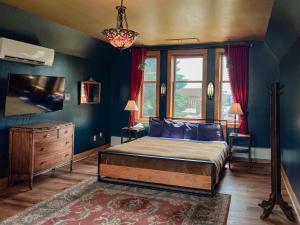 a bedroom with a bed with blue walls and a tv at Endion Inn in Duluth