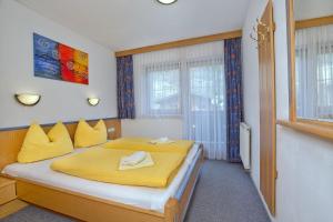 クリムルにあるApartment Ferienwohnung Bacherのベッドルーム1室(黄色いシーツ付きのベッド1台、窓付)