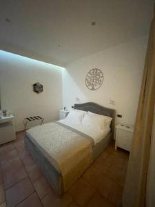 a bedroom with a bed and a clock on the wall at la Maison del Mas Gold in Elmas