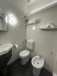 a white bathroom with a toilet and a sink at la Maison del Mas Gold in Elmas