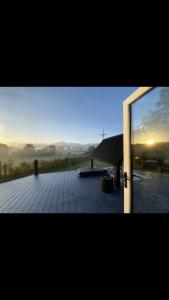 a door to a deck with a view of the sunset at The Hut 45 in Newry