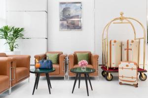 a waiting room with chairs and tables and luggage at Golden Sands Hotel & Residences in Sharjah