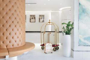 a luggage cart sitting next to a chair at Golden Sands Hotel & Residences in Sharjah