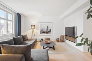 a living room with a couch and a tv at Dinesen Collection Luxury Condos in Copenhagen