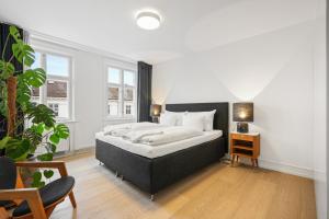 a bedroom with a large bed and a night stand at Dinesen Collection Luxury Condos in Copenhagen