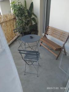 a patio with a bench and a table and chair at A Poitiers, 2 chambres, très bel appartement de 65 m2 in Poitiers